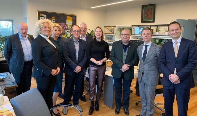 Minister Cora van Nieuwenhuizen tijdens een ontbijtsessie in het Aalsmeerse gemeentehuis met burgemeester Gido Oude Kotte, wethouder Schiphol Bart Kabout en een afvaardiging van de Aalsmeerse gemeenteraad.
