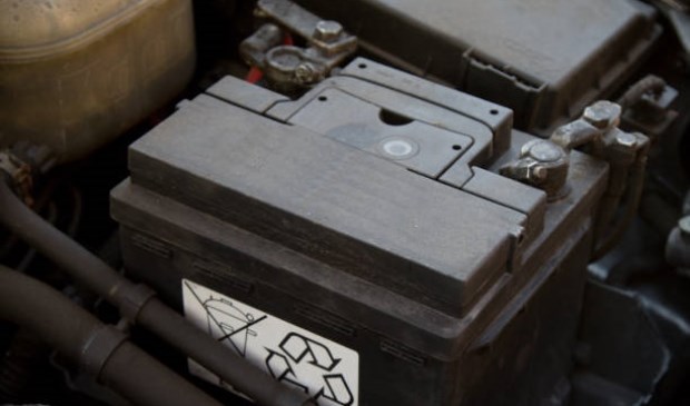 A car battery in place in an engine bay