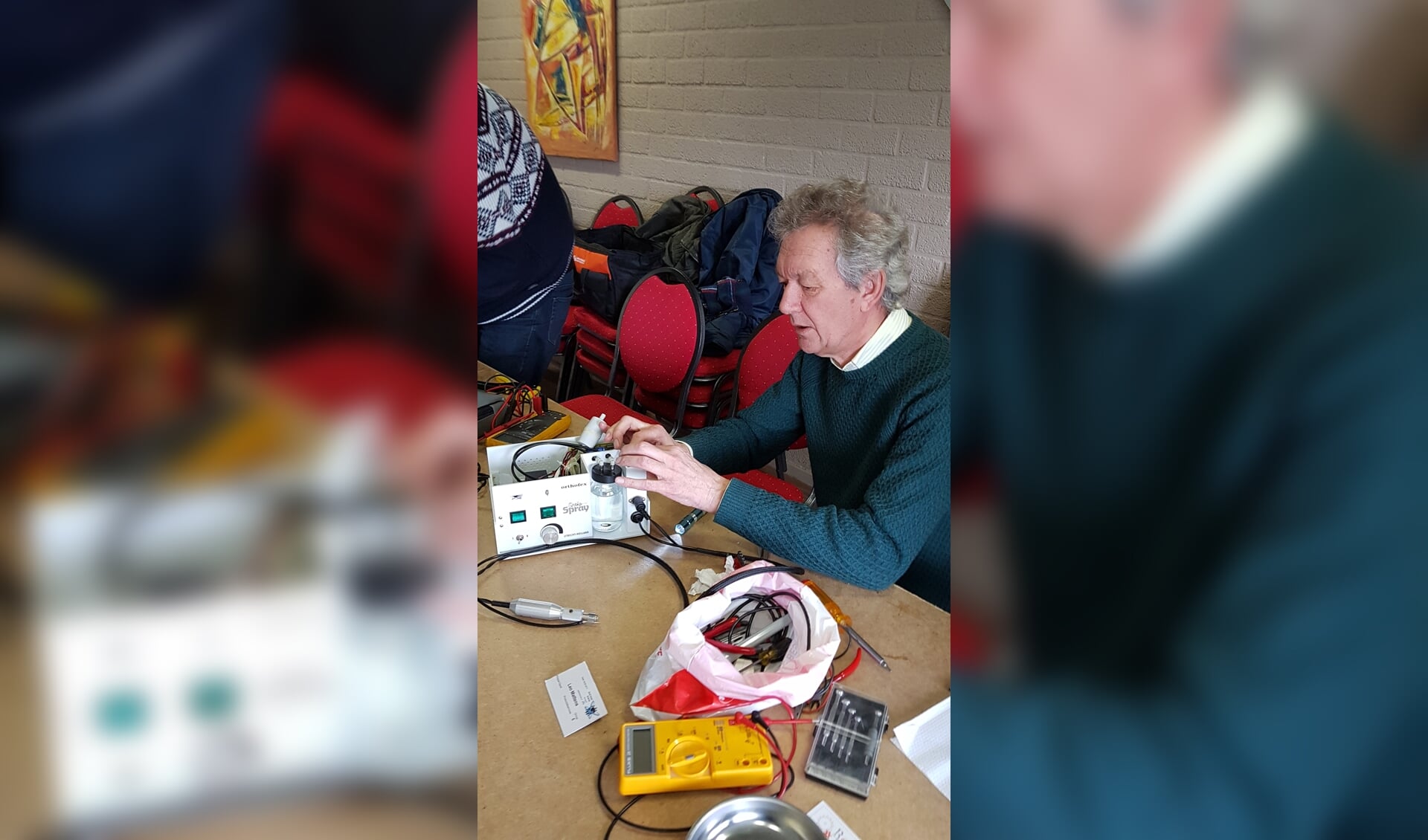 Een medewerker van het Repair Café Badhoevedorp weet met veel geduld de waterverstuiver te maken.