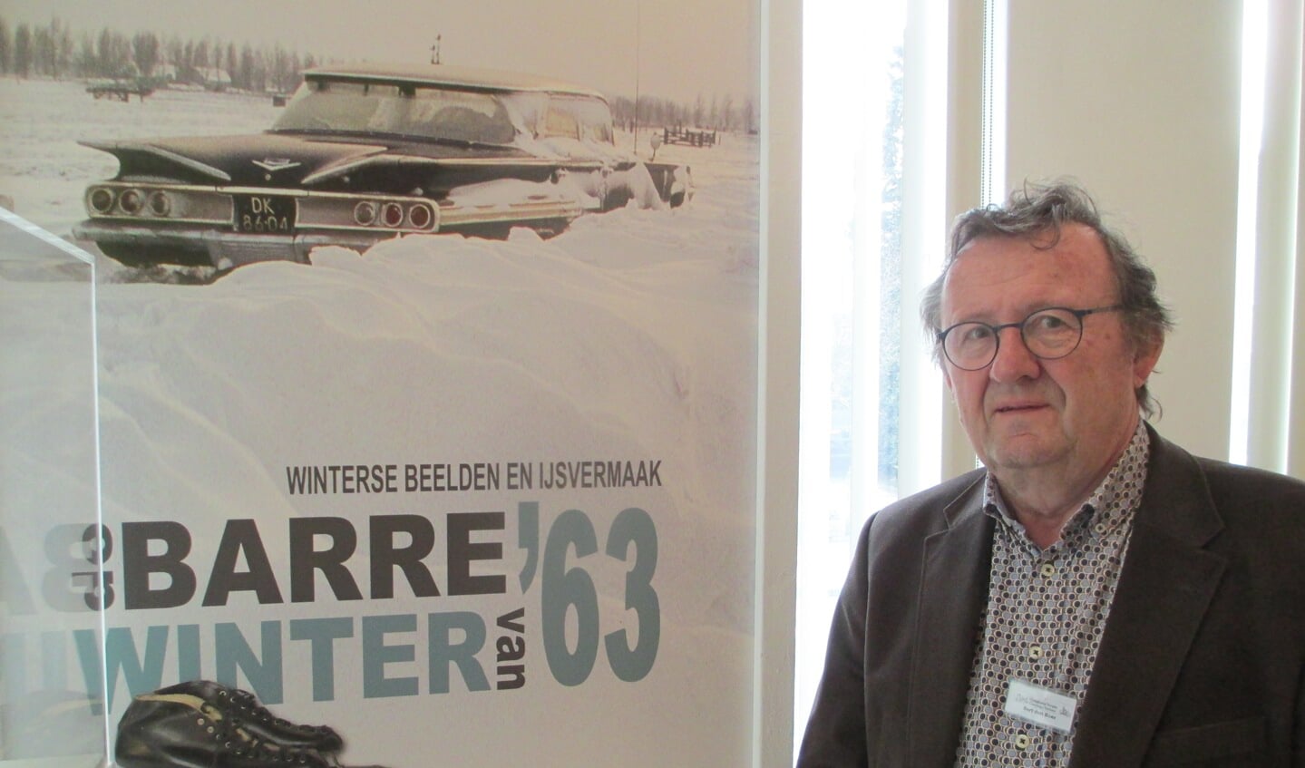 Bert den Boer bij het affiche met de ingesneeuwde taxi van Jan Rozendaal.