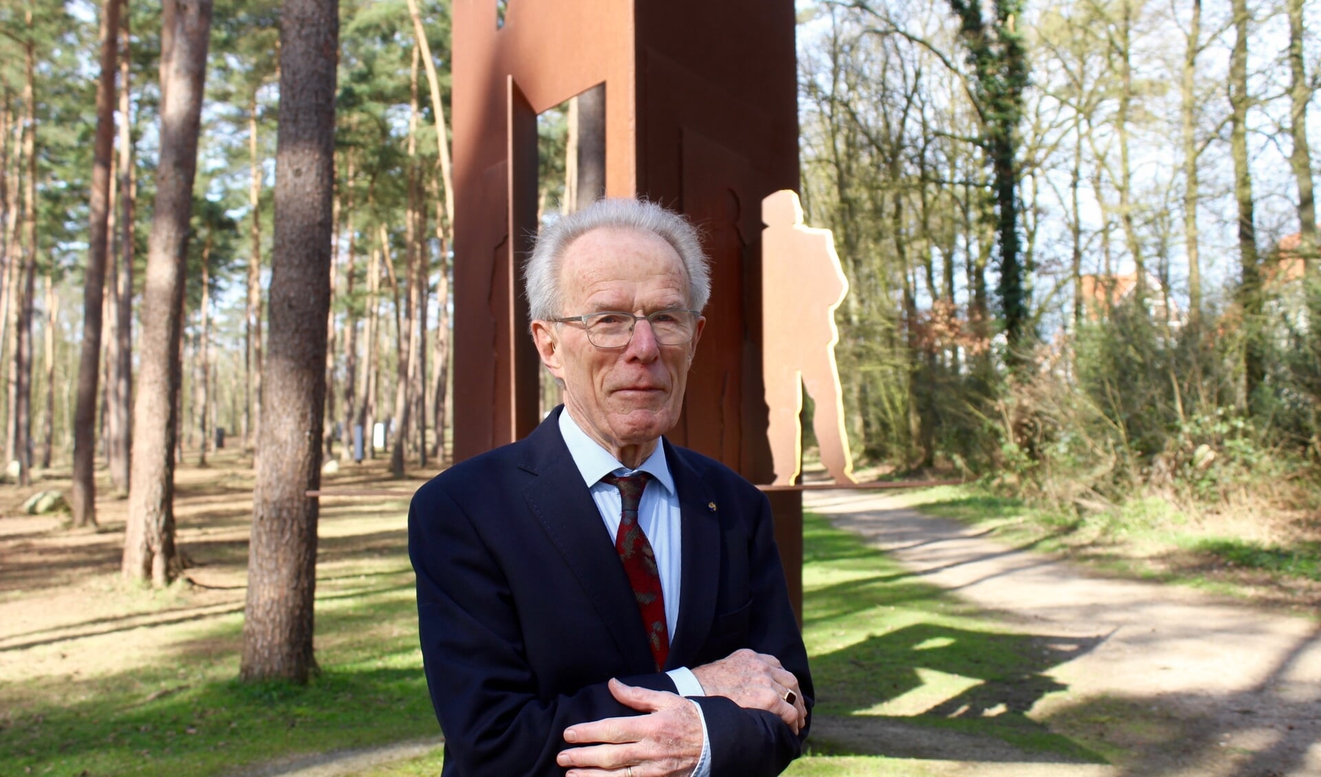 Jan Slomp bij het monument voor schuilplaatsverleners, van kunstenaar Eric Claus, in het bos schuin tegenover de ingang van Kamp Amersfoort. 