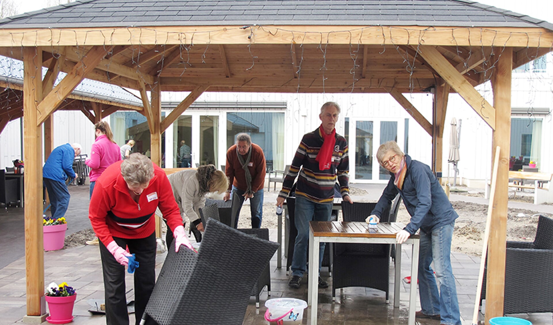 Vrijwilligers van de Rotaryclub schrobden het tuinmeubilair bij Klaasje Zevenster schoon tijdens NLdoet in 2018. 
