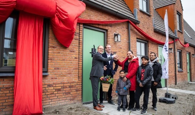 Remco Pols (Ymere) en Frits Lely (Van Wijnen) feliciteren de eerste huurders met hun nieuwe woning.