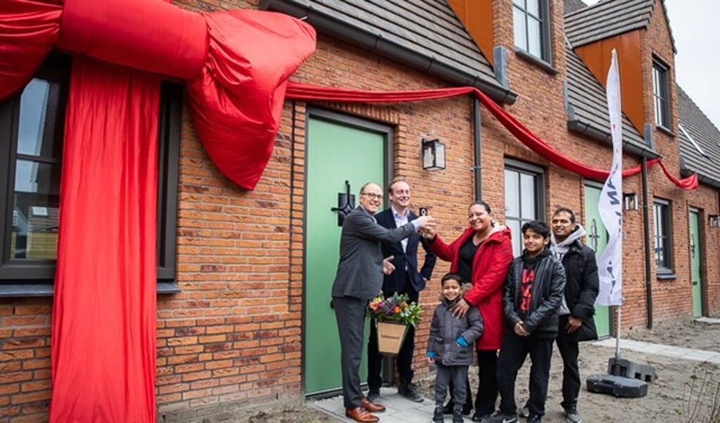 Remco Pols (Ymere) en Frits Lely (Van Wijnen) feliciteren de eerste huurders met hun nieuwe woning.
