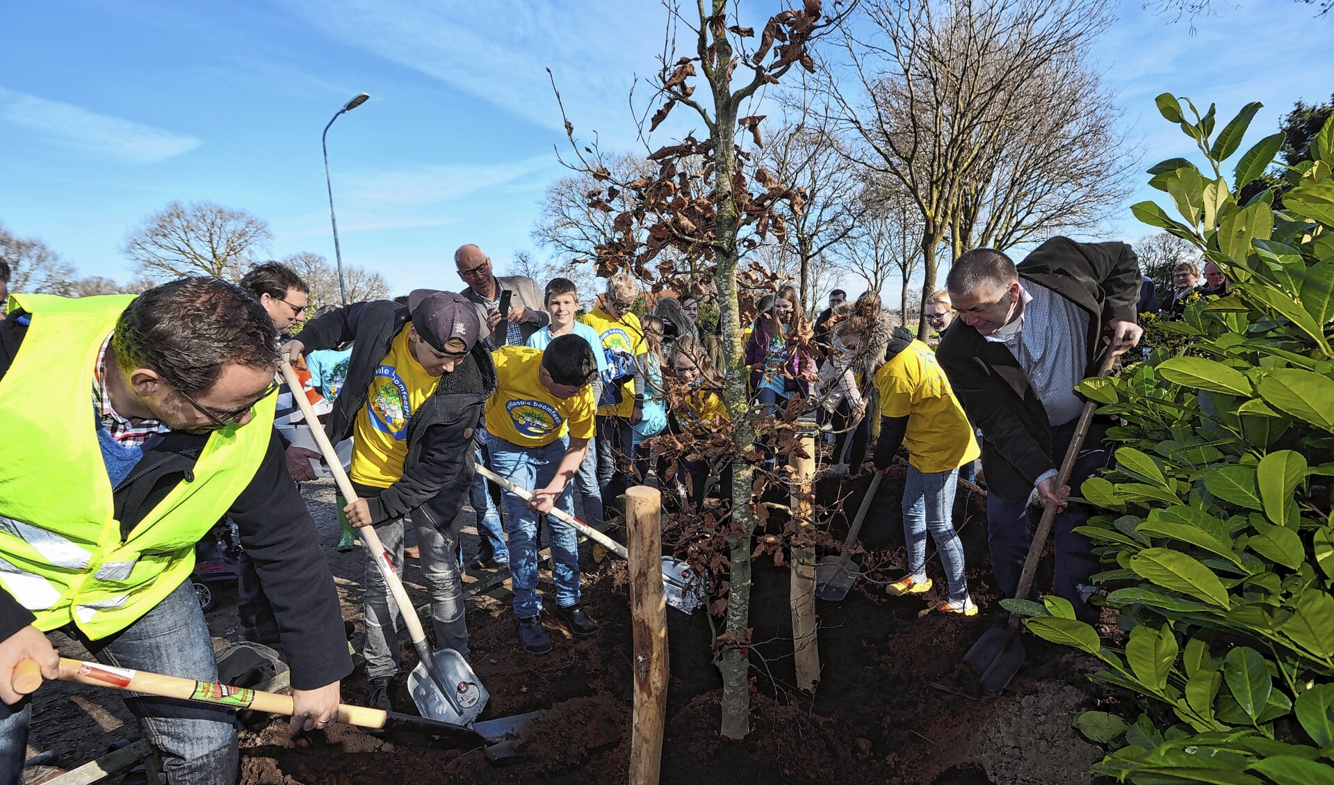 Wethouder Koekoek plant een boom op school Huinen tijdens boomfeestdag 2017.