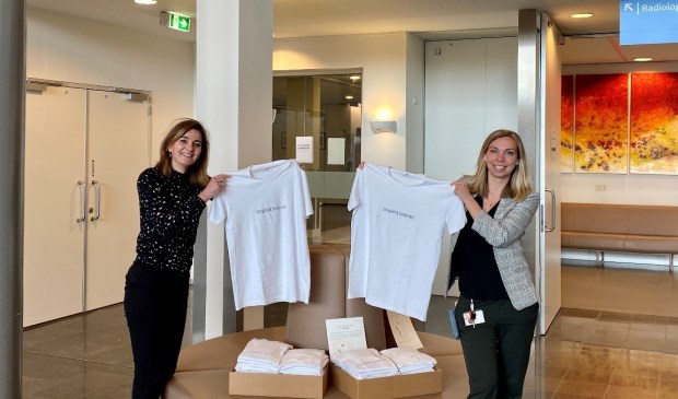 Lisette de Rooy en Annelies Putters-Kloet van het Spaarne Gasthuis nemen de T-shirts in ontvangst.