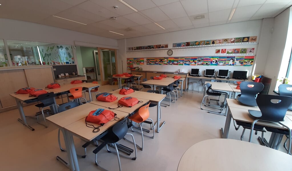 De lespakketten voor thuis liggen voor de leerlingen klaar in een verder leeg klaslokaal. 