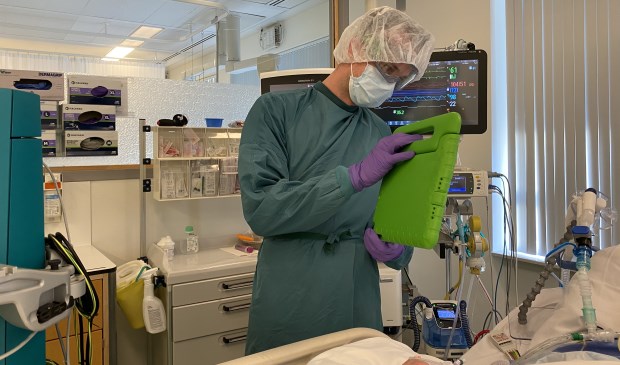 Een IC-verpleegkundige laat via beeldbellen aan familie zien hoe de patiënt in bed ligt