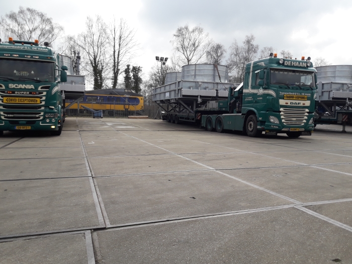 een paar van de beladen vrachtwagens tijdens het laden bij Bronswerk op het terrein