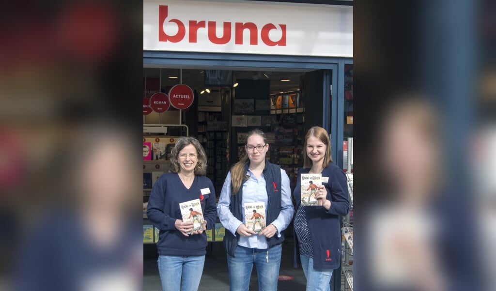 Drie medewerksters van Bruna met het boek van Terlouw.