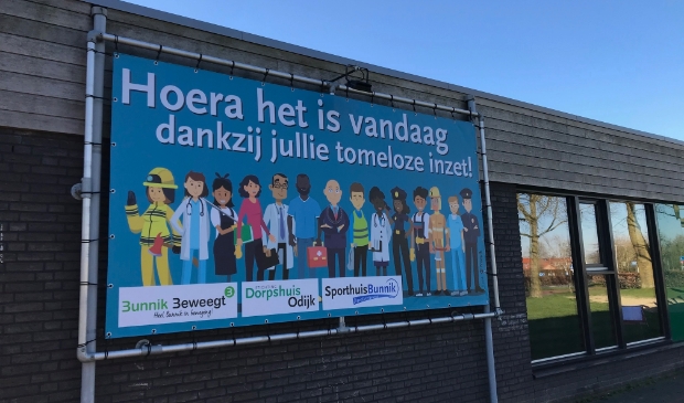 <p>De supportposter die aan de gevel van Dorpshuis Odijk hing aan het begin van de pandemie</p>