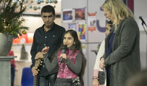 Abdullah uit Landgraaf met zijn dochter Naja geinterviewd door Esther op een Syrie feestavond.(foto Jan ten Haaf)