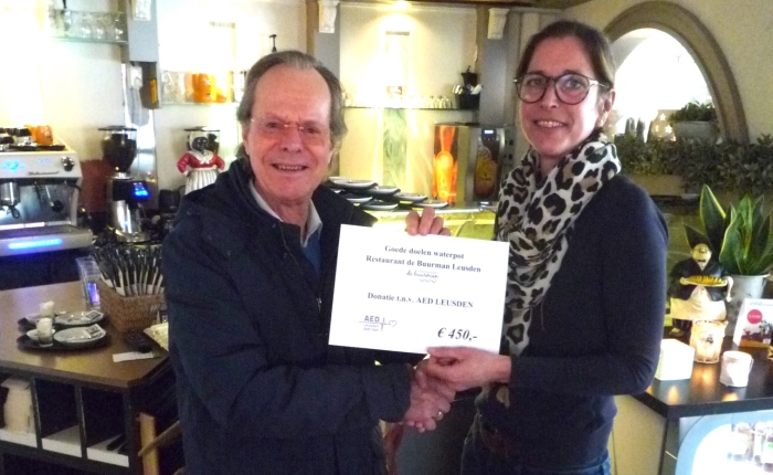 Jeff de Vries ontvangt de cheque voor een AED kast uit handen van Nadine Veeneman van restaurant de Buurman