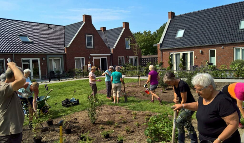 Bewoners van een Knarrenhof in Zwolle aan het werk in de gezamenlijke tuin. 