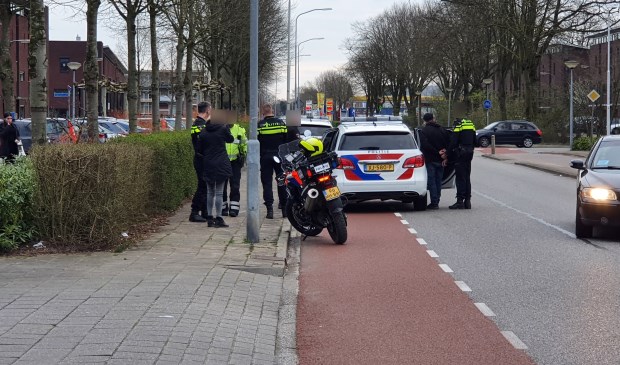 De verdachte wordt in de politieauto gezet
