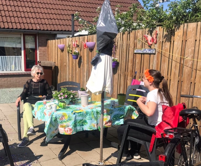2 maatjes eten samen corona-proof een oranje tompouce