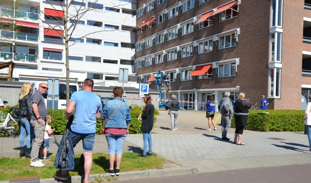 De familie wacht geduldig, op gepaste afstand