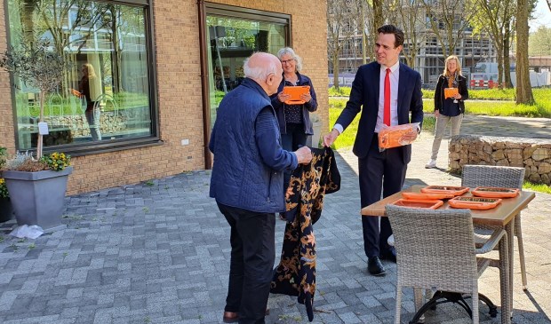 Wethouder Marijn van Ballegooien reikt de eerste tablet uit.