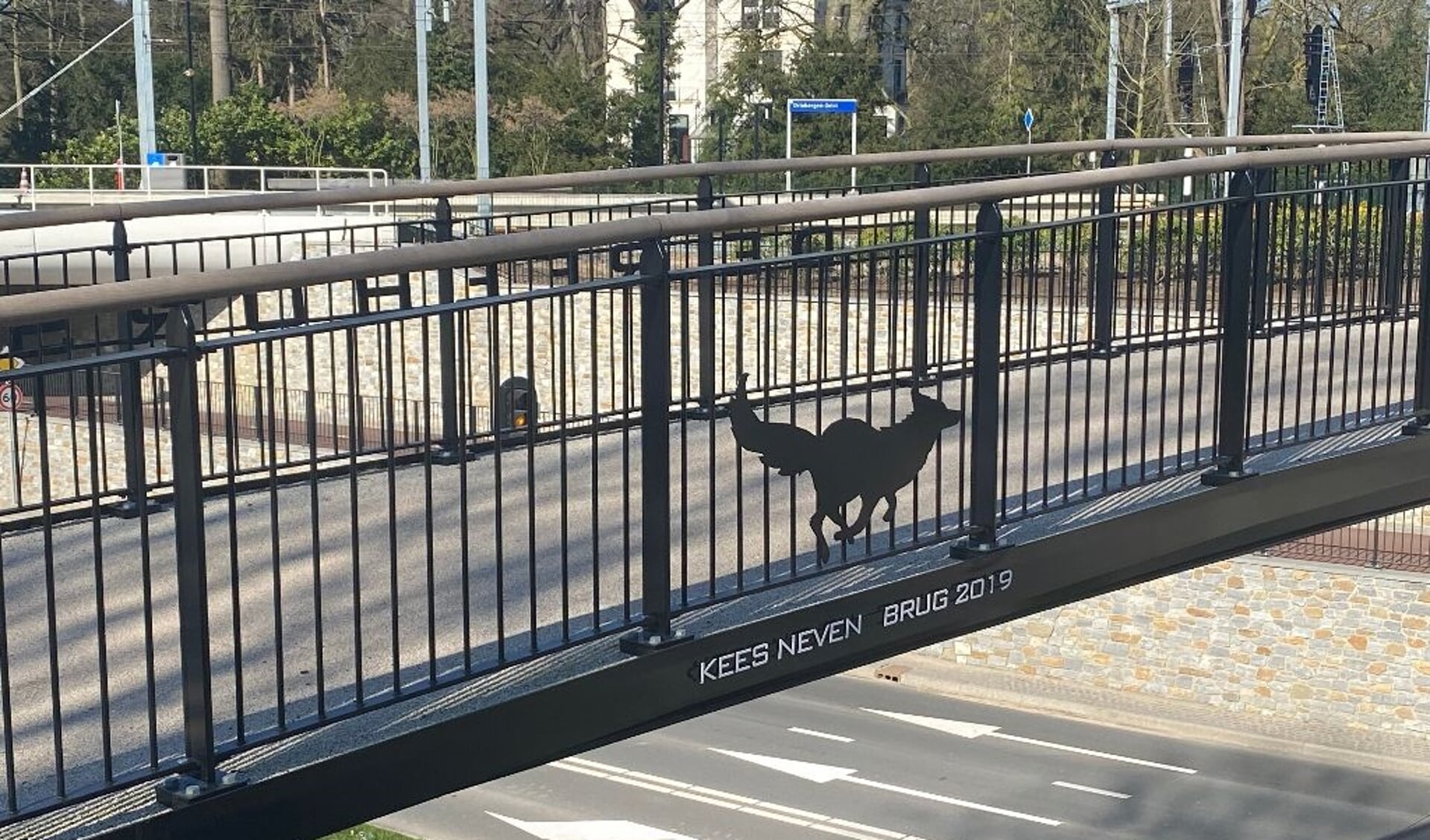 De naam van Kees Neven staat als eerbetoon op de fietsbrug.