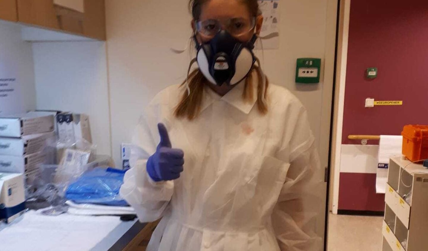 Romy Beetstra, van top tot teen gekleed in beschermende kleding op de huisartsenpost