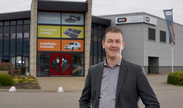 Evert Bos voor het pand van Bos Installatietechniek, waarop de nieuwe huisstijl is doorgevoerd.