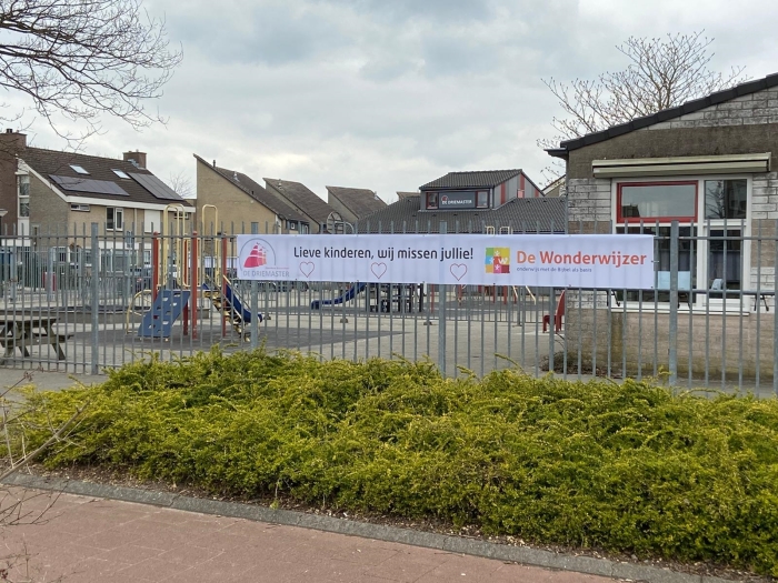 De banner aan het hek bij basisschool de Wonderwijzer