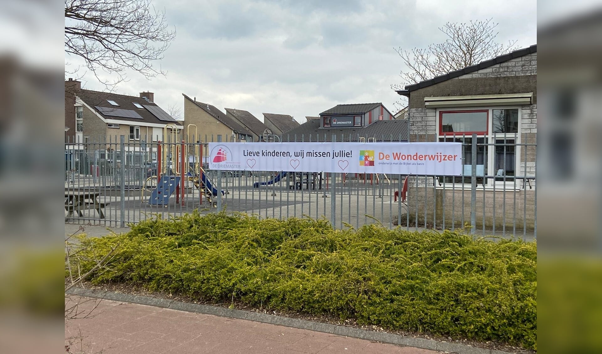 De banner aan het hek bij basisschool de Wonderwijzer