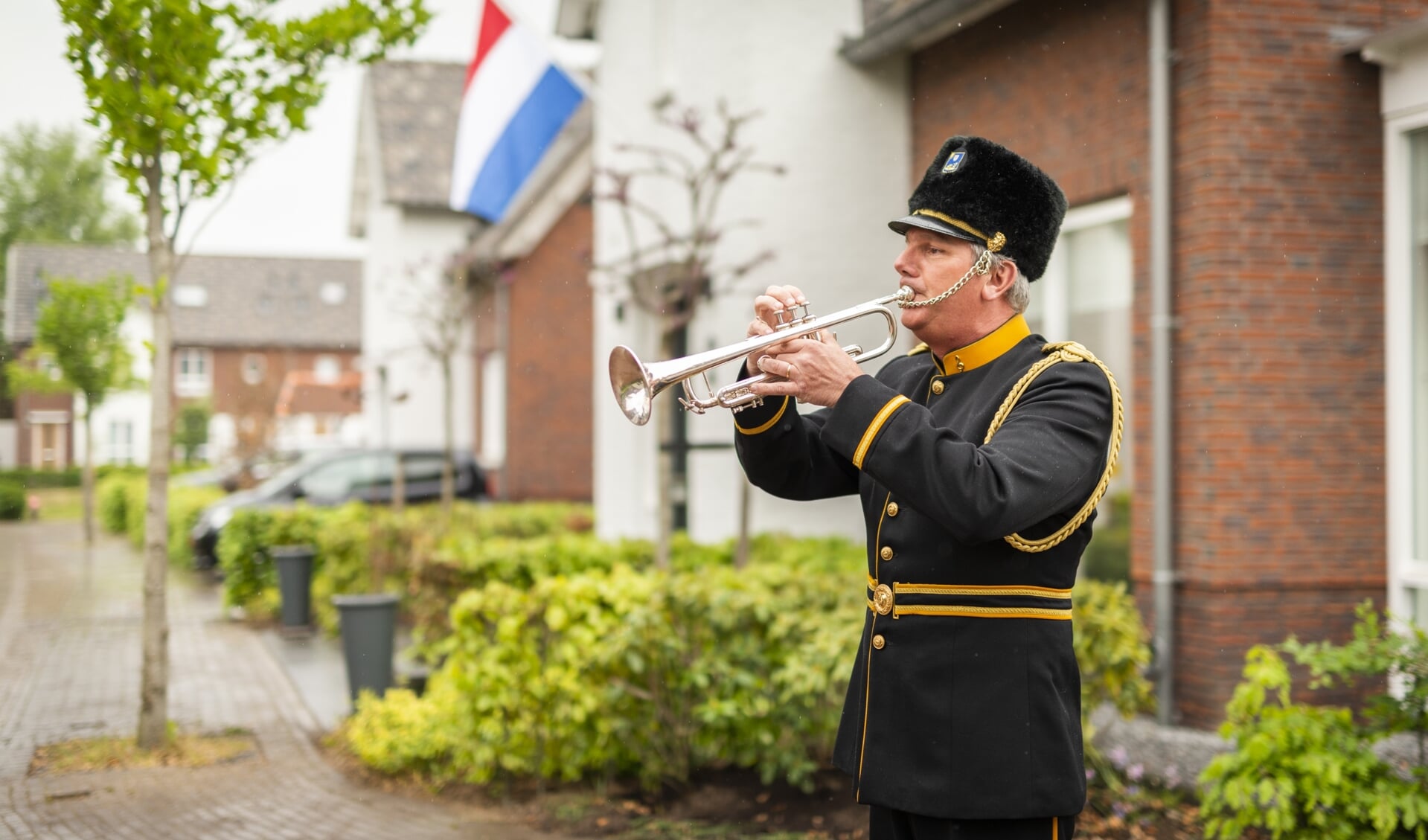 Wim Overduin speelt het taptoe-signaal op 4 mei voor zijn huis in Barneveld.