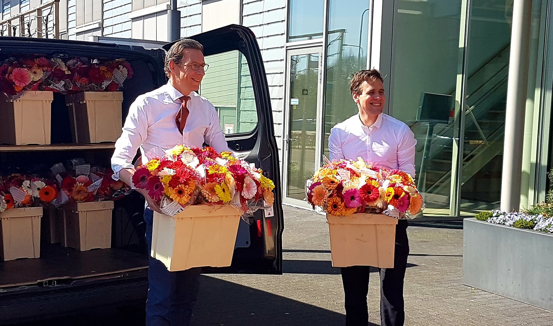 Burgemeester Tjapko Poppens en wethouder Zorg Marijn van Ballegooijen geven bloemen en paaschocola af bij het Zonnehuis in Amstelveen.