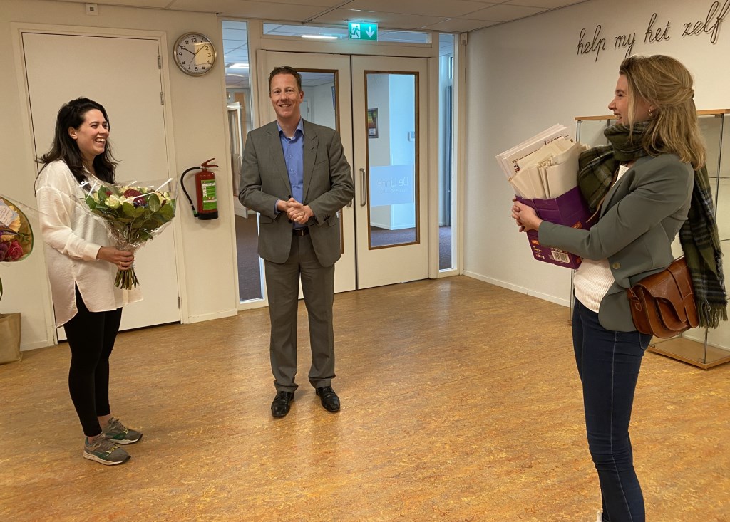 Wethouder Frank Berkhout en Marloes Smit geven directeur Bijlsma van de Linde een doos met Amstelkids.
