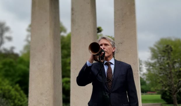 Nico Schimmel van Harmonie Orkest Amstelveen blaast het taptoe-signaal bij het oorlogsmonument aan de Amsterdamseweg.