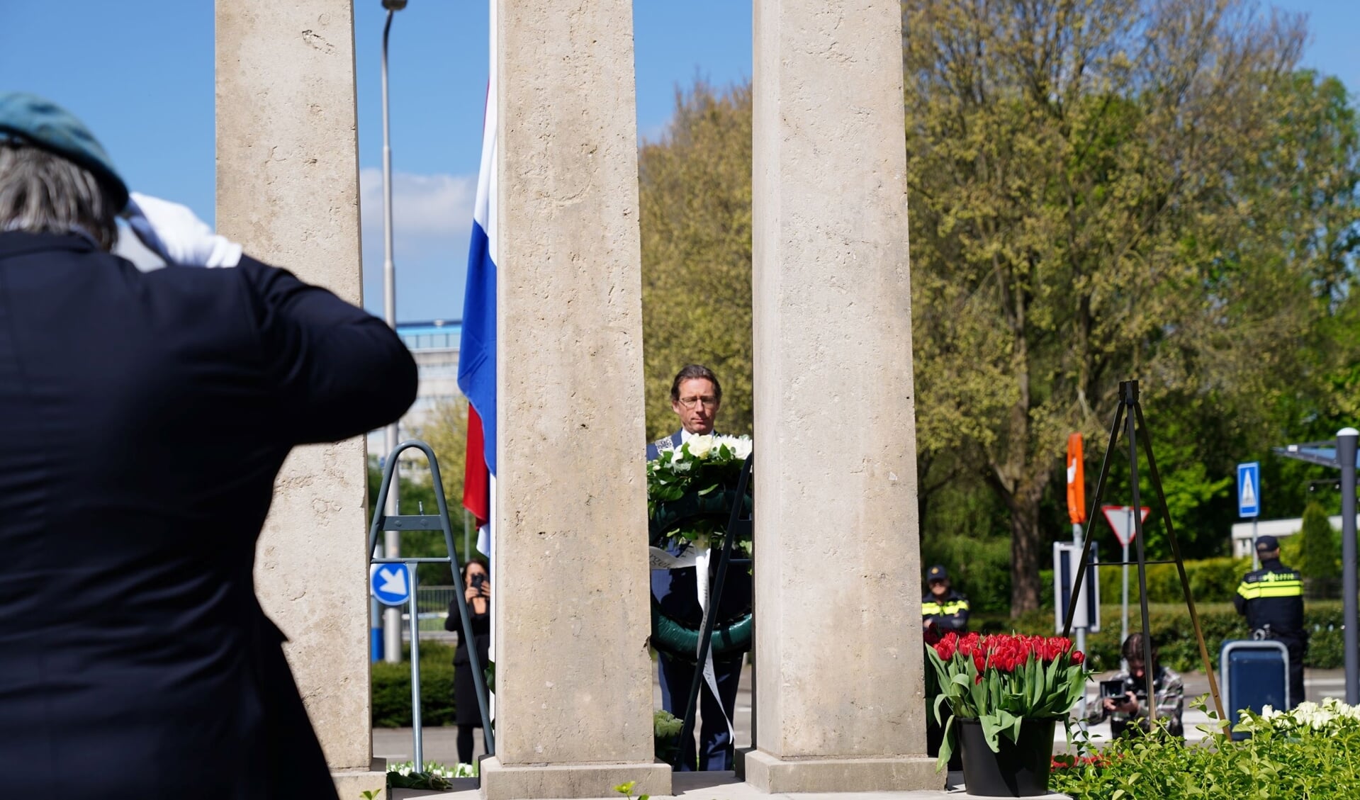 Burgemeester Tjapko Poppens legt als eerste een krans bij het monument aan de Amsterdamseweg.