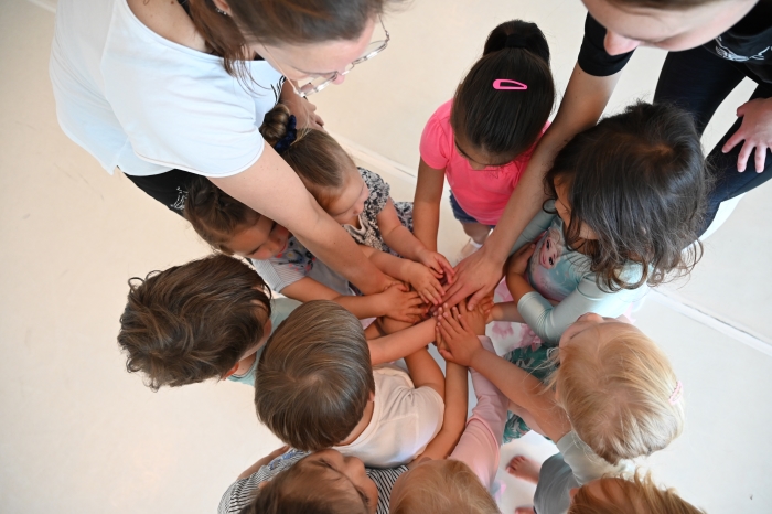 Samen doen waar je blij van word dansen. Kinderhanden op een stapel. Geen gezichten