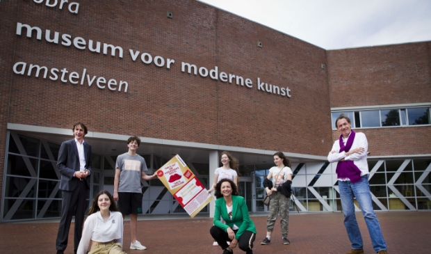 Wethouder Herbert Raat, Cobra-directeur Lillian Bóza, Stefan van Raay en enkele middelbare scholieren met de voucher voor het Cobra Museum.