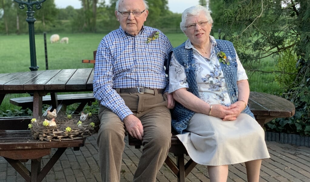 Opa en oma Verbeek op de picknickbank in hun tuin