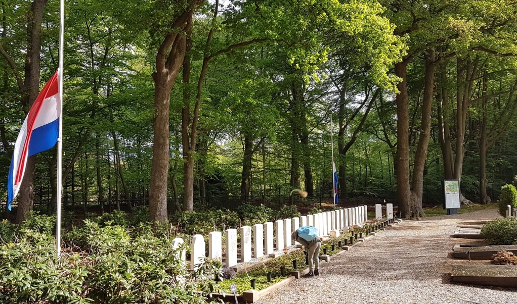 Maandag 4 mei, begraafplaats Ede, een kind verdiept zich in de graven van gesneuvelde militairen in de Tweede Wereldoorlog.