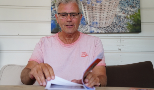 Dick Backer bladert door de proefdruk van zijn vierde boekje.