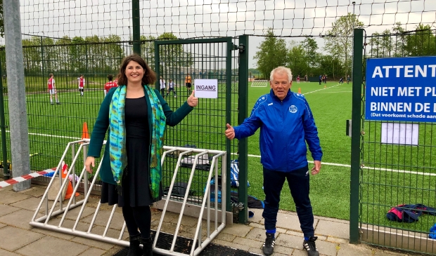 Wethouder Barbara de Reijke en jeugdtrainer Gerard Sieverding bij de ingang van een van de sportvelden.