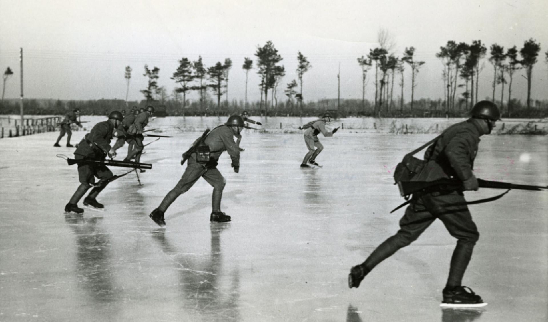 Foto 1: Als onderdeel van de mobilisatie worden gebieden onder water gezet, zoals hier in de omgeving van Leusden. Op 11 januari 1940 oefenen Nederlandse militairen op de schaats met wapens bi de Vijfde Kom aan het Valleikanaal, ook wel de Asschatterkom genoemd.