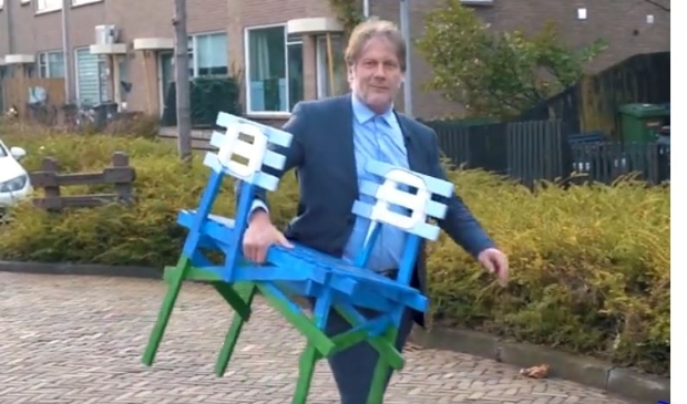 Wethouder Ro van Doesburg met de Dwarszitter onder zijn arm