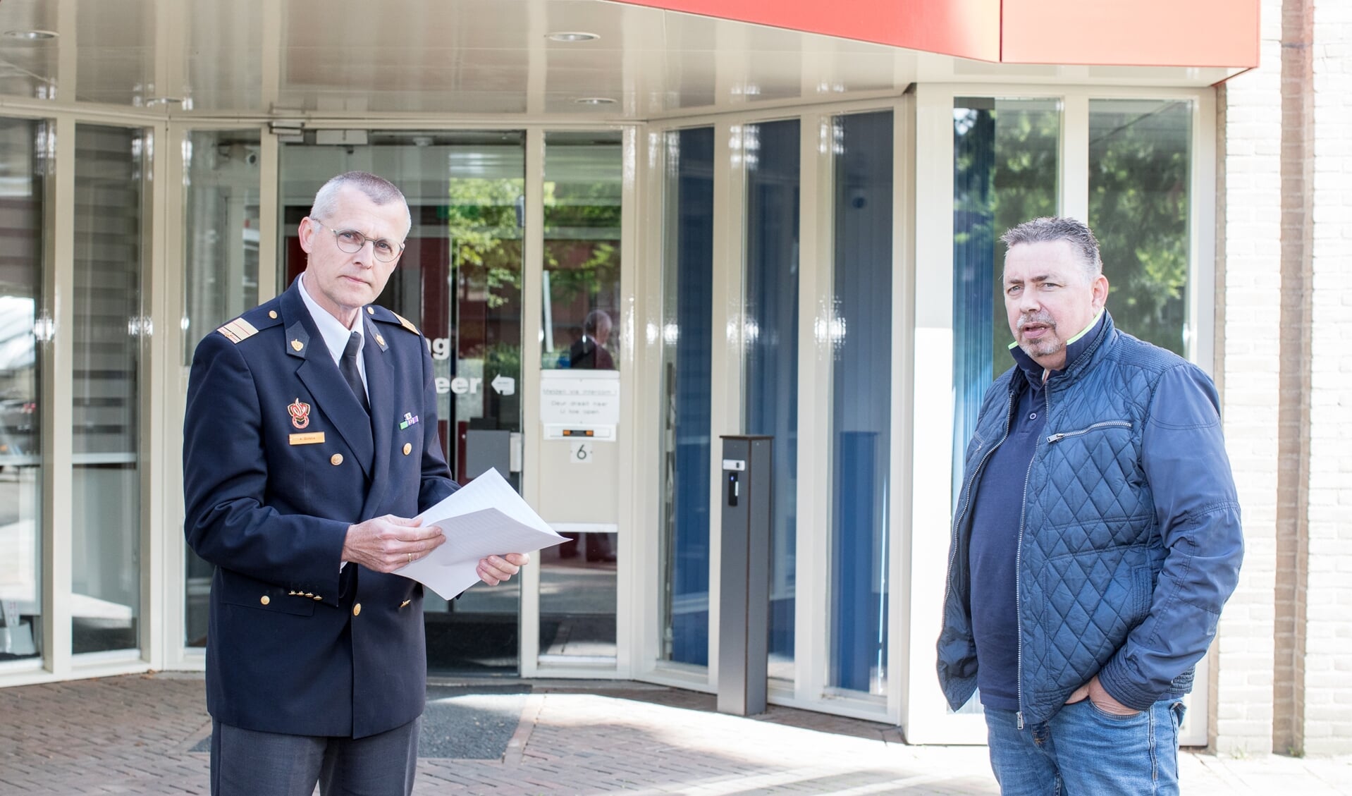 Inwoner Harro Timmerman (rechts) heeft donderdag de petitie aangeboden aan brandweercommandant Anton Slofstra (links).