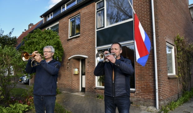 Leo en Adri Verlaan van PVO spelen The Last Post vanuit de tuin.