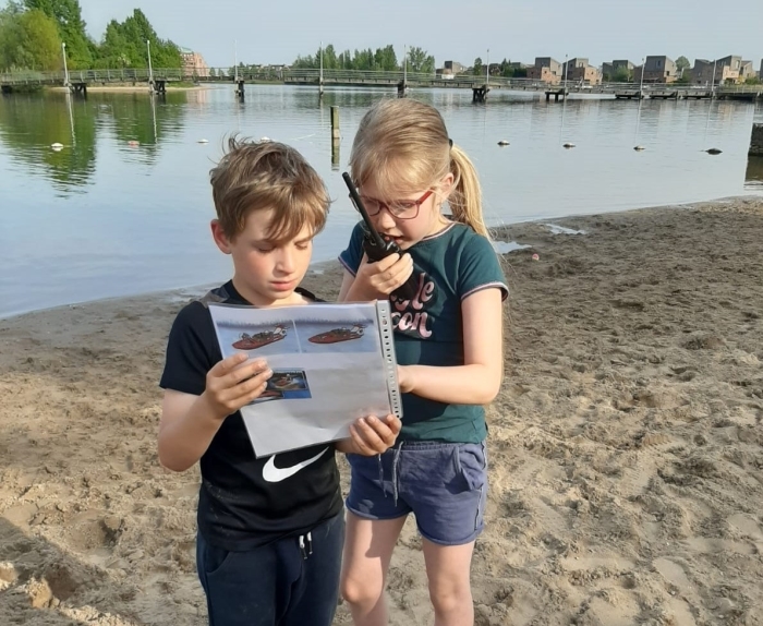 Voor het eerst oefenen met een portofoon, en zo een ander groepje vertellen wat op de foto staat.