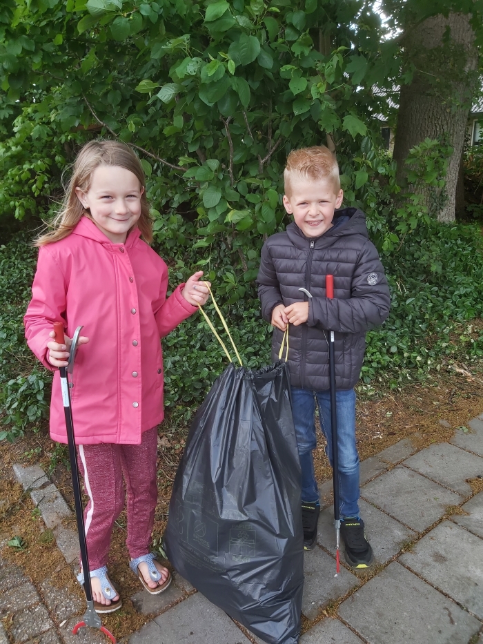 Arno en Juliet met de opbrengst van hun schoonmaakactie.