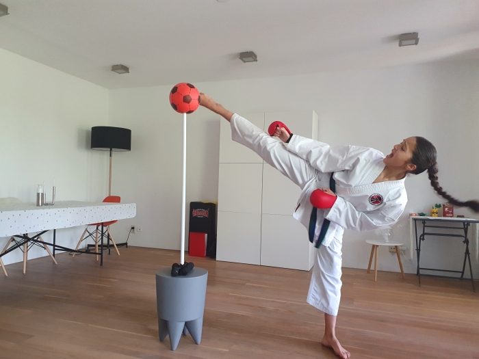 Imane Valk (12) trappend in actie in de woonkamer tijdens een virtueel karatekampioenschap