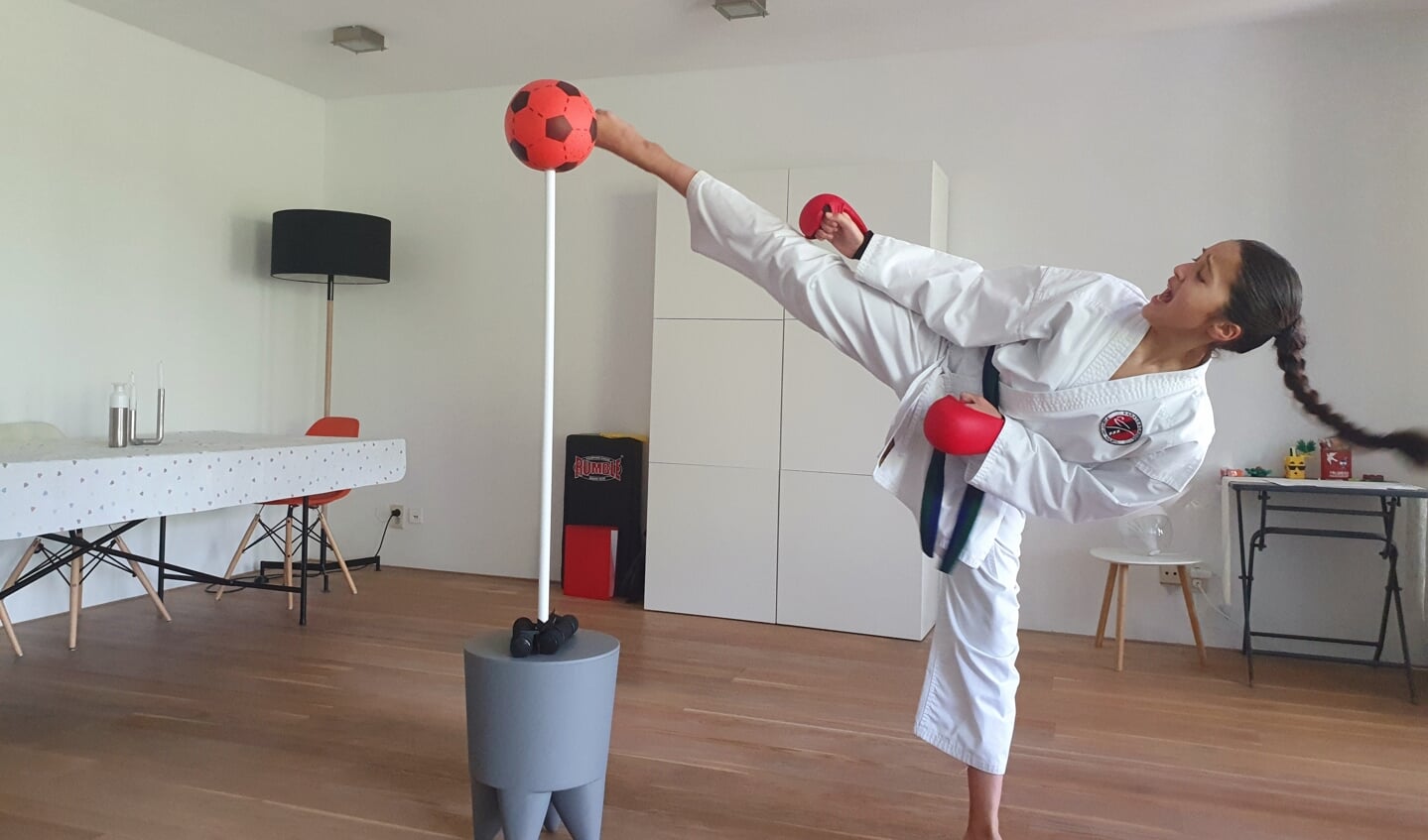 Imane Valk (12) trappend in actie in de woonkamer tijdens een virtueel karatekampioenschap
