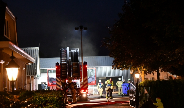 De brandweer forceerde met een kettingzaag een opening in de roldeur van de loods.