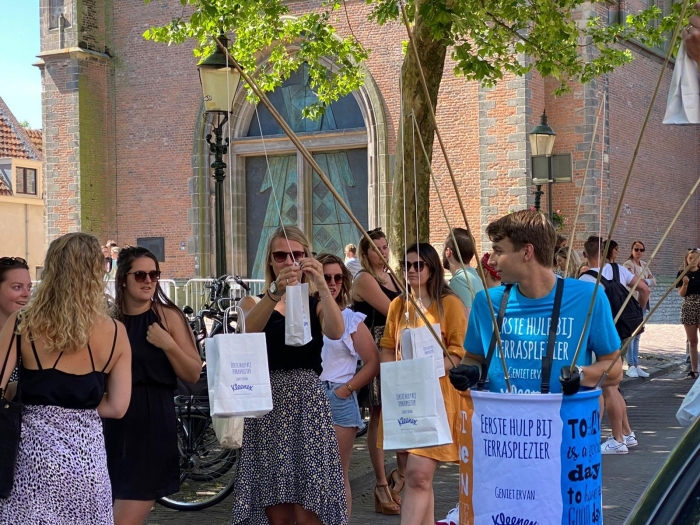 Eerste Hulp bij Terrasplezier team deelt tasjes uit om veilig en met veel plezier van het terras te genieten. In het tasje o.a. Kleenex Balsam zakdoekjes, water fresh tissues, een rolmaat, hartjes en een kaartje voor het horecapersoneel.
