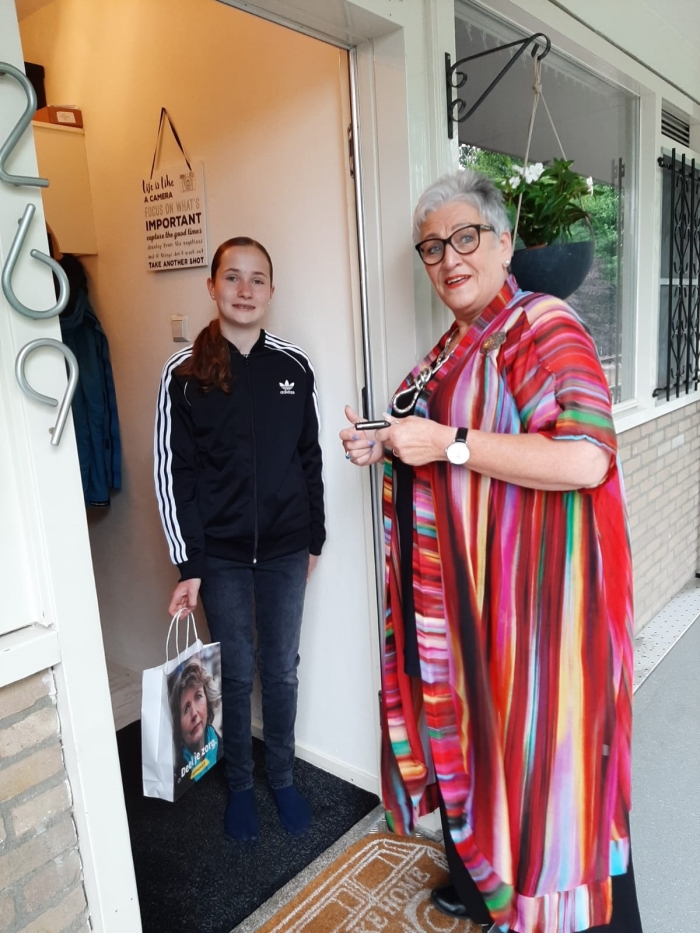 Jonge mantelzorger Anouk krijgt een tasje aangeboden door Corry, medewerkster van Mantelzorg & Meer