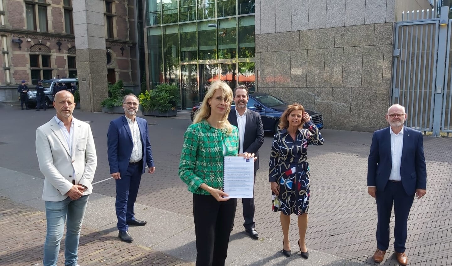 Staatssecretaris Mona Keijzer van economische zaken met de petitie van de touringcarbedrijven.